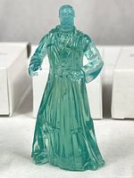 Front view of one translucent Obi-Wan figure standing, mailer boxes in background