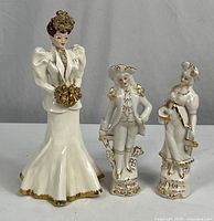 All three porcelain figurines side by side showing relative sizes and design details