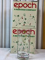 Two original Epoch boxes and one tumbler positioned in front