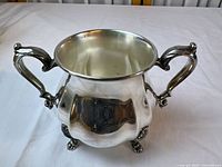 Front view of silver-plated sugar bowl showing handles and feet