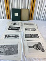 Box with lid removed showing stacked loose-leaf prints spread out