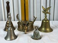 Group shot showing all five items: four bells and deer-head bowl
