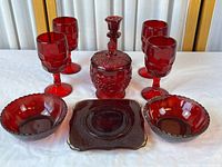 Group shot showing four goblets, lidded candy dish, candlestick, two bowls and square plate