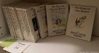 Shelf view showing multiple white hardcover Beatrix Potter gift editions, three covers facing front