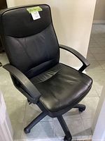 Front view of black faux leather office chair showing seat, backrest, and armrests