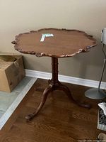 Full view of pedestal side table showing top and tripod base