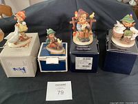 Four figurines on their boxes, overall lot view
