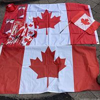 Overall lot showing two large unfolded flags, packaged flags, miniature flags, cap