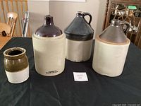 Group shot of three jugs and one small crock on table
