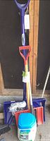 Bundle showing blue shovel, red handle, snow brush, ice melt