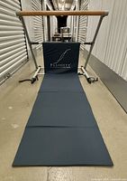 Front view showing barre, unfolded mat, Fluidity logo