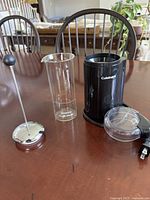 Overall view of both items: Bonjour milk frother disassembled and Cuisinart coffee grinder with lid and cord