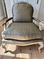 Front view of bergere chair showing silk upholstery and carved frame