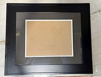 Front view of black wood frame with double mat and cardboard insert