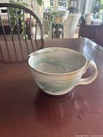 Angled front view of ceramic mixing bowl showing handle and spout