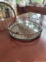 Angle view showing metal scroll frame, glass insert, handles