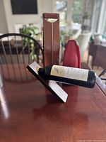 Wooden stand shown holding wine bottle for scale