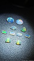 All 10 opals on black background showing shape variety and colour play