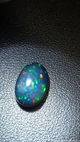 Oval black opal showing multicolour flashes