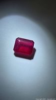 Front view of emerald cut ruby under spotlight