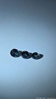 Three round blue sapphires on neutral background