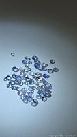 Group of loose round light violet-blue tanzanite stones on white background
