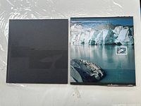 Slipcase and open book showing glacier image and mounted stamp