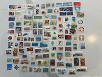 Wide view of entire assortment of mint Canadian stamps laid out on countertop