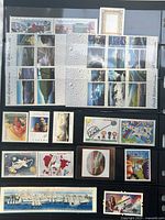 Two album pages filled with unused Canadian stamps, top page showing blocks of landscape and commemorative designs, lower page with singles, thematic sets and souvenir issues