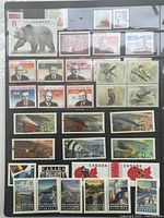 First album page with wildlife, portraits, birds, locomotives, maple leaf stamps