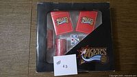 Front view of boxed 76ers poker set showing two card decks, chips and dice