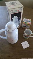 Coffee carafe beside its box and Hawaii mug