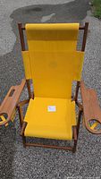 Full view of assembled yellow director chair showing wooden frame and cup holders