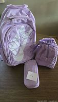 Front view of lavender Nike backpack, lunch bag, pencil case