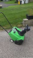 Left side view of Lawn-Boy 320R snow thrower showing housing, wheels, handlebar and chute