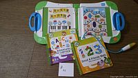 LeapFrog LeapStart system open with stylus and three Level 1 preschool books visible