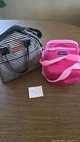 Black/white striped tote and pink lunch bag on table