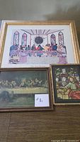 Overall view of three framed religious prints on tabletop