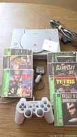 Console, controller, memory card, cables and seven game cases on tabletop