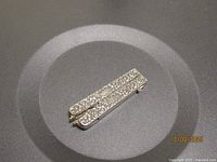 Full view of pendant showing rectangular shape and scroll design