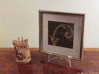Elephant figurine and framed fabric displayed together