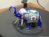 Left side of blue Meenakari elephant figurine showing floral saddle and beads