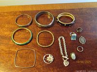 All items laid out showing rings, bracelets, pin, pendant
