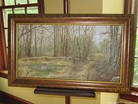 Full view of framed painting on easel