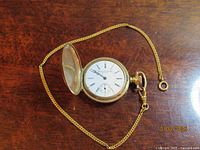 Open pocket watch showing dial marked Plymouth Watch Co. U.S.A. and attached chain
