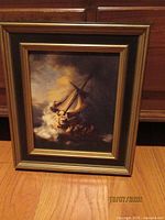 Full view of framed print standing on floor