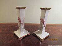 Front view of both porcelain flamingo candlesticks