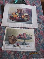 Both watercolors displayed together on rug