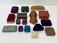 Sixteen assorted vintage jewelry boxes laid out for overview