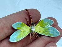 Front view showing enamel wings and rhinestone body